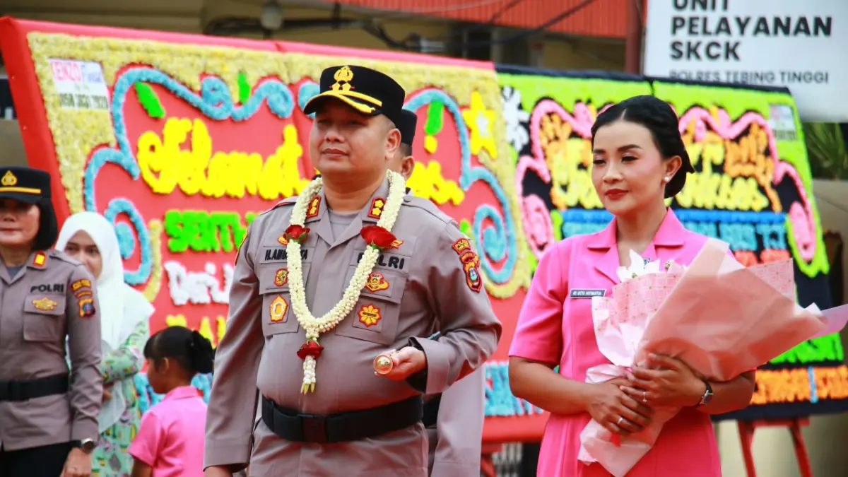 Kapolres Tebingtinggi AKBP Hotmartua Ambarita, S.H., S.I.K., M.H. mendapat pengalungan bunga, sementara Ketua Bhayangkari Cabang Tebing Tinggi Ny. Gitta Hotmartua Ambarita menerima buket bunga saat disambut jajaran Polres Tebing Tinggi dalam acara pisah sambut di Mapolres Tebinginggi, Jumat (18/9/2026). (Azan Purba, Sumut Pos)
