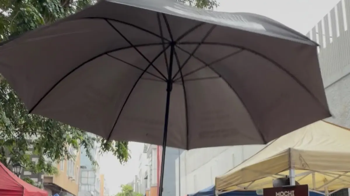 SENYUM: Pedagang kaki lima di CFD tersenyum bahagia saat menerima payung dari TikTok Shop di CFD Medan, Minggu (20/9/2026). (Dok: panitia)