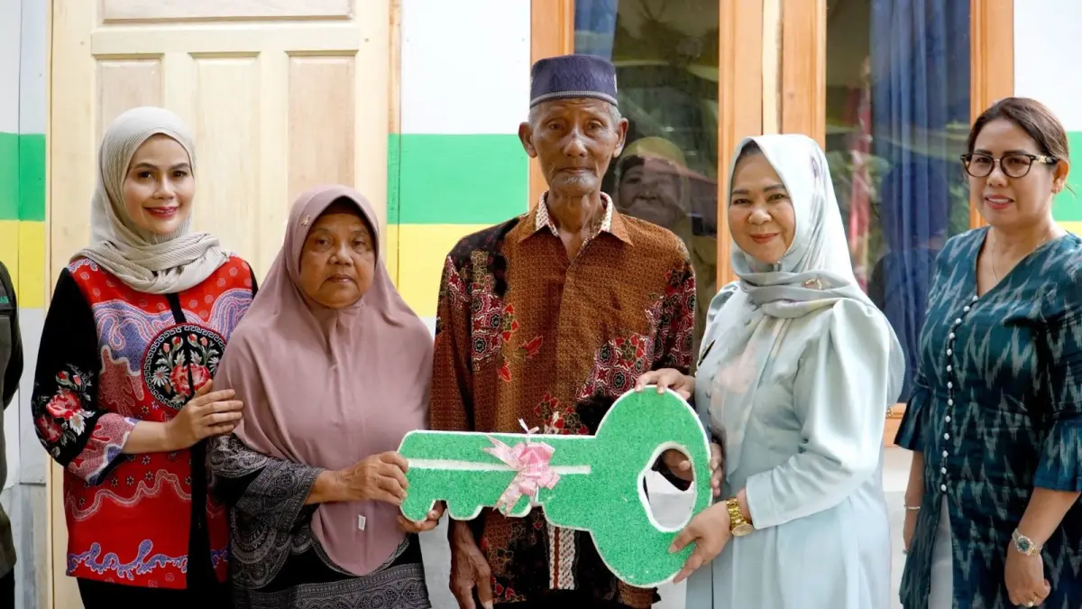 KUNCI: Plt Bupati Langkat, Tiorita br Surbakti saat menyerahkan kunci setelah melakukan rehab rumah masyarakat. (Dok: Diskominfo Langkat)
