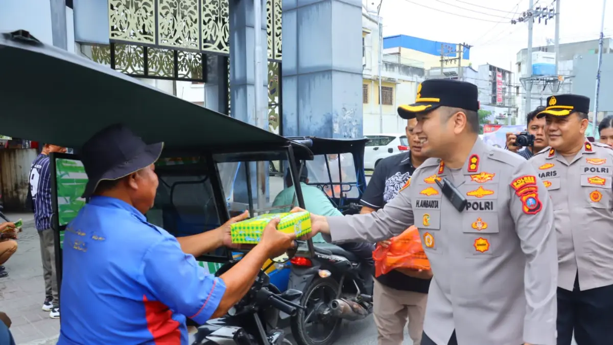 MAGER: Kapolres Tebingtinggi AKBP Hotmartua Ambarita menyerahkan makanan kepada warga dalam program Mager (Makan Gratis), didampingi Wakapolres Kompol M. Haris S., Jumat (25/9/2026), (Dok: Azan Purba/Sumut Pos)