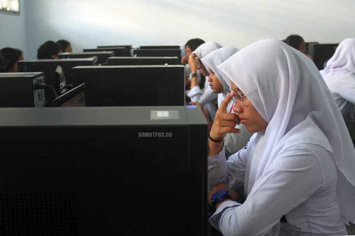 SUTAN SIREGAR/SUMUT POS UNBK SISWA SMK_Seorang siswi mengerjakan soal Ujian Nasional di Sekolah SMKN 10 Medan Jalan Teuku Cik Ditiro, Senin (3/4). Ada 149 SMK di Kota Medan, Sumatera Utara yang menggelar Ujian Nasional Berbasis Komputer (UNBK). Sementara