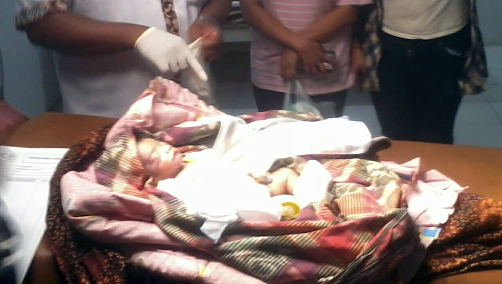 Foto: Anita/PM Bayi berusia seminggu, yang ditinggalkan seorang ibu bertubuh gemuk, di sebuah warung kopi di Berastagi, Tanah Karo, Sabtu (1/7). Setelah dicek ke klinik, si bayi ternyata sakit dan akhirnya meninggal.