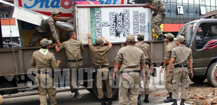 Foto : ist Keterangan foto: Penertiban papan reklame yang dilakukan Pemko Medan di depan salah satu minimarket di Jalan Sisingamaraja, Senin (10/7).
