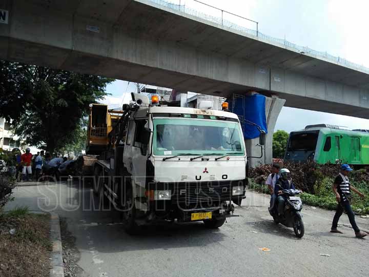 Foto: Parlindungan Harahap/Sumut Pos Truk pengangkut alat berat mogok di tengah rel kereta api di Jalan AR Hakim Medan.  Akibatnya kereta api menuju Kualanamu terpaksa menginjak rem mendadak.