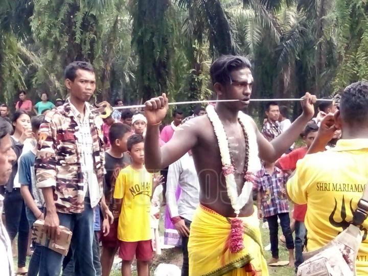 Foto: BAMBANG/SUMUT POS CUCUK: Seorang umat Hindu mencucuk kedua pipinya menggunakan besi hingga tembus, tanpa merasa sakit, Minggu (30/7).
