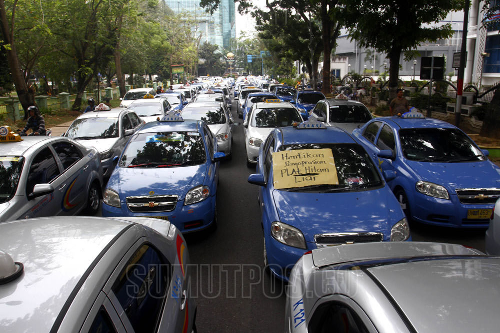 Foto: DANIL SIREGAR/SUMUT POS Ratusan sopir taxi yang tergabung dalam Kesper Sumut dan Isotarban KNIA, melakukan aksi unjukrasa di depan gedung DPRD Sumut, Medan, Senin (4/4). Dalam aksinya, mereka menuntut pemerintah untuk menghapus dan menertibkan pengo