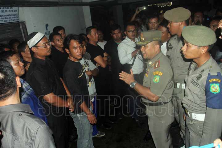 SUTAN SIREGAR/SUMUT POS BERDEBAT_Kasatpol PP Sofyan memberikan peringatan kepada karyawan PT TLJ yang menghalangi eksekusi pengelola pasar Pringgan jalan Iskandar Muda Medan, Selasa (26/9) Eksekusi tersebut berakhir ricuh pihak PT TLJ melawan eksekusi ber