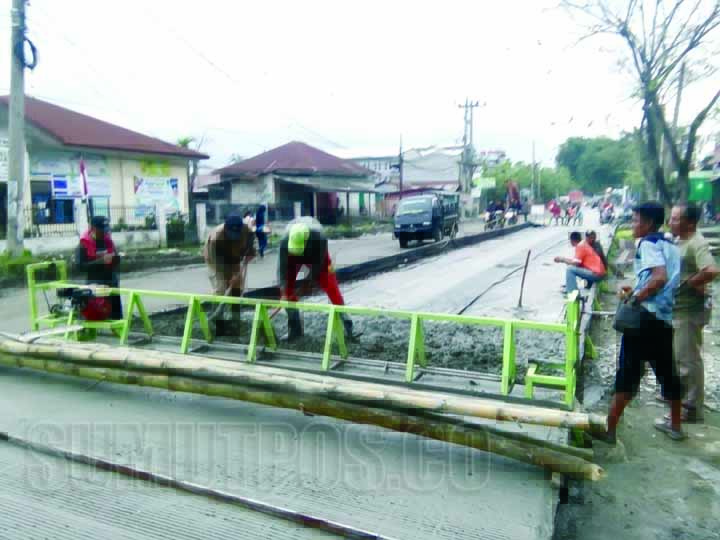 Foto: Fachrul Rozi/Sumut Pos Sejumlah warga memantau pekerja proyek pembangunan Jalan Titi Pahlawan melakukan pengecoran.