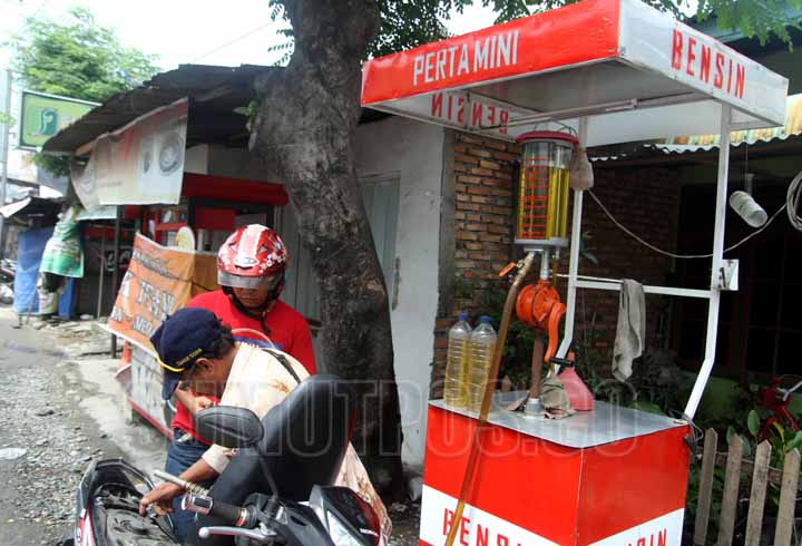SUTAN SIREGAR/SUMUT POS FENOMENA PERTAMINI_Seorang pedagang eceran mengisi bbm pengendara sepeda motor di Jalan Mochtar Basri Medan, Sabtu (4/3) Fenomena SPBU eceran atau yang sering disebut Pertamini semakin meluas di kota medan.