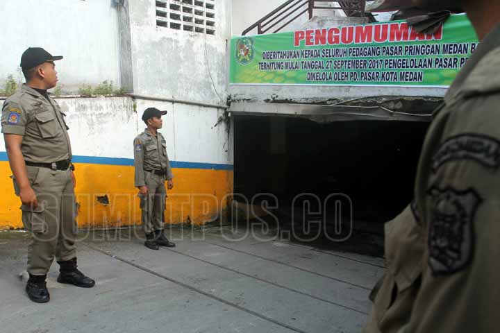 SUTAN SIREGAR/SIREGAR BERJAGA_Beberapa petugas Satpol PP berjaga di pintu masuk basemant pasar pringgan jalan Iskandar muda Medan, Rabu (27/9) Pasca pengosongan kantor PT TLJ petugas satpol PP berjaga-jaga di pasar pringgan.