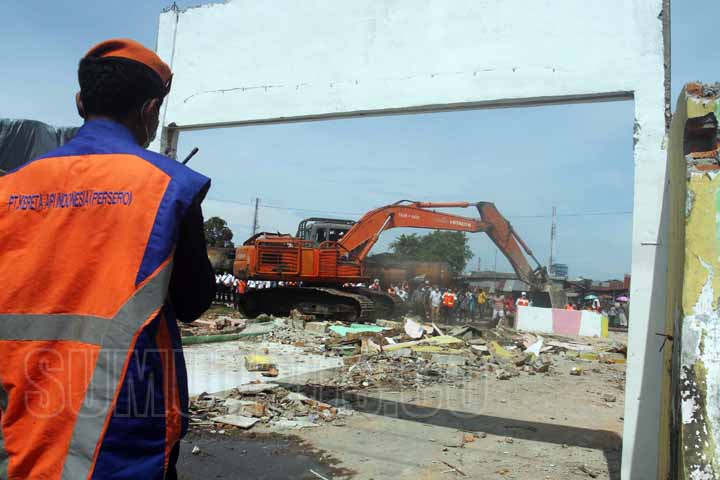 SUTAN SIREGAR/SUMUT POS MELAWAN_Alat berat terlihat merobohkan bangunan yang beridir dikawasan pinggiran rel di Jalan Stasiun kereta api lama Belawan Medan, Kamis (14/9). Kegiatan tersebut terkait rencana pembangunan jalur rel ganda kereta api dari stasiu