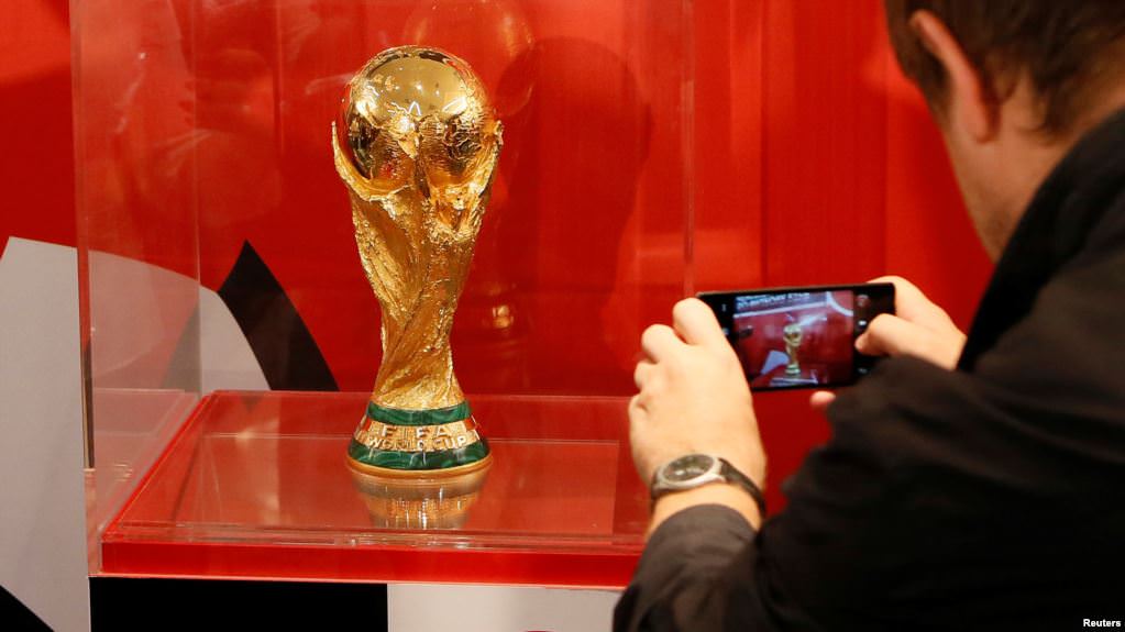 Foto: REUTERS/Ilya Naymushin  Seorang pria mengambil foto trofi Piala Dunia FIFA setelah konferensi pers FIFA World Cup Trophy Tour 2017 di Kasnoyarsk, Siberia, Rusia, 10 September 2017.