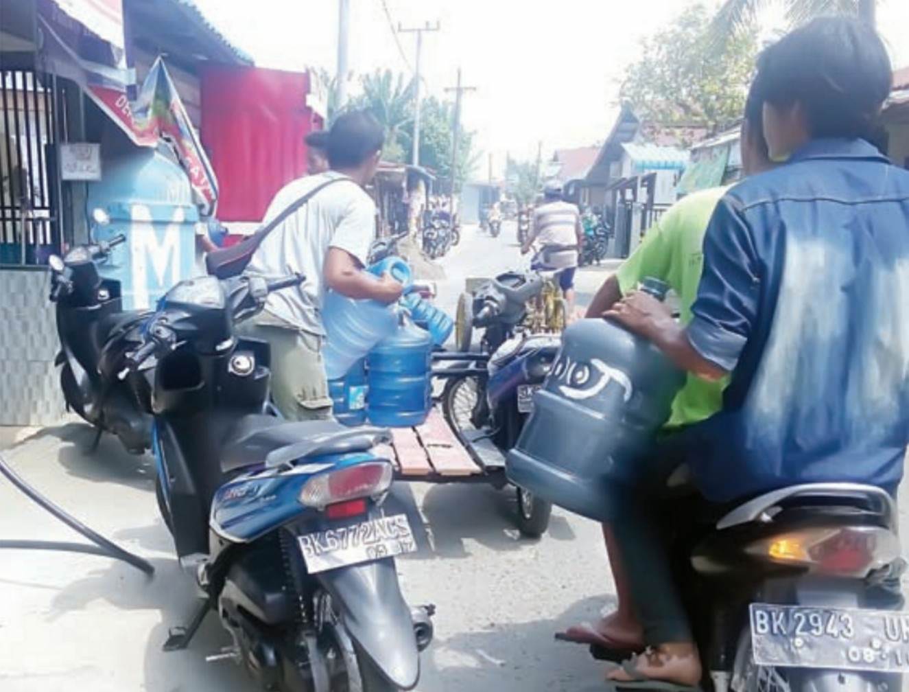 Foto: SUTAN SIREGAR/SUMUT POS BELI AIR: Warga Jalan Purwo membeli air isi ulang di depot air untuk keperluan sehari-hari karena air PAM mati, Senin (23/10).