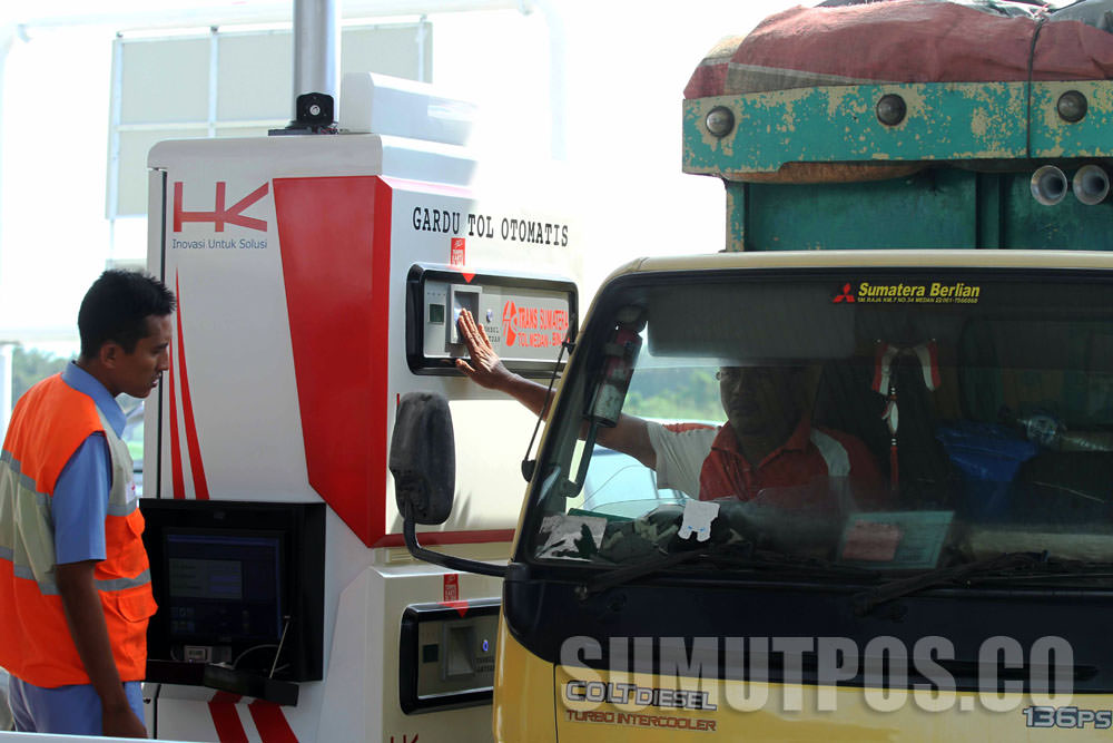 SUTAN SIREGAR/SUMUT POS E-TOLL_Seorang pegendara menggunakan e-toll saat memasuki pintu tol Helvetia Medan, Senin (16/10) Setelah di resmikan presiden RI Joko widodo, Jalan tol kualanamu-Tebing tinggi dan Medan-Binjai di gratiskan sampai tanggal 19 oktobe