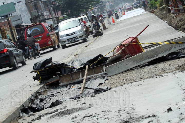 SUTAN SIREGAR/SUMUT POS JALAN DENAI_Pengendara bermotor melintas di samping pengerjaan jalan yang belum selesai pengerjaan nya di Jalan Denai Medan, Jumat (6/10) Pengerjaan tersebut tidak kunjung selesai dan terkesan terbengkalai.