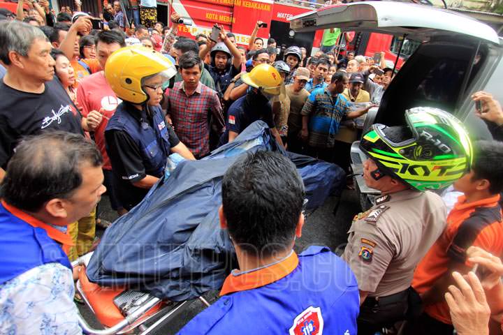 SUTAN SIREGAR/SUMUT POS EVAKUASI_Petugas pemadam, PMI dan BPBD Kota Medan mengevakuasi penghuni rumah toko, Albert yang sempat terjebak di lantai dua rumahnya saat terjadi kebakaran, di Jalan Bogor Medan, Kamis (12/10). Satu orang tewas, dan satu orang la