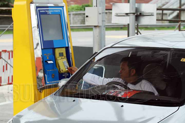 Foto: SUTAN SIREGAR/SUMUT POS Seorang pengemudi mobil pengguna jalan tol bertransaksi menggunakan kartu elektronik non tunai ketika akan keluar dari tol Belmera Amplas Medan, Minggu (8/10). PT Jasa Marga sudah memberlakukan pembayaran di gerbang tol Belme