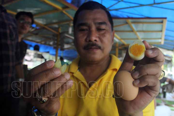 SUTAN SIREGAR/SUMUT POS MENUNJUKAN_Seorang warga menunjukan telur yang diduga palsu di Jalan Agus Salim Medan, Kamis (20/10) Warga tersebut membeli telur yang diduga palsu di pasar sembada, Tekstur telur kenyal menyerupai karet dan tidak memiliki bau amis