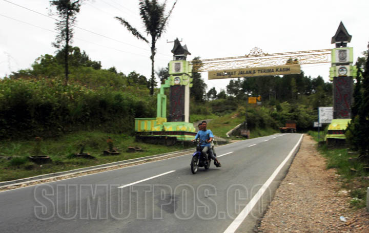 TRIADI WIBOWO/SUMUT POS Sejumlah warga melintasi jalan lintas sumatera menuju danau toba, Kabupaten Tapanuli Utara, Selasa (22/3)
