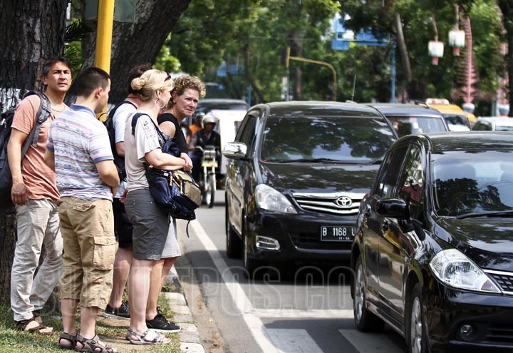 TRIADI WIBOWO/SUMUT POS Sejumlah turis asing ingin menyebrang jalan di tengah padatnya lalu lintas di jalan Dipenegoro Medan, Selasa (12/5).