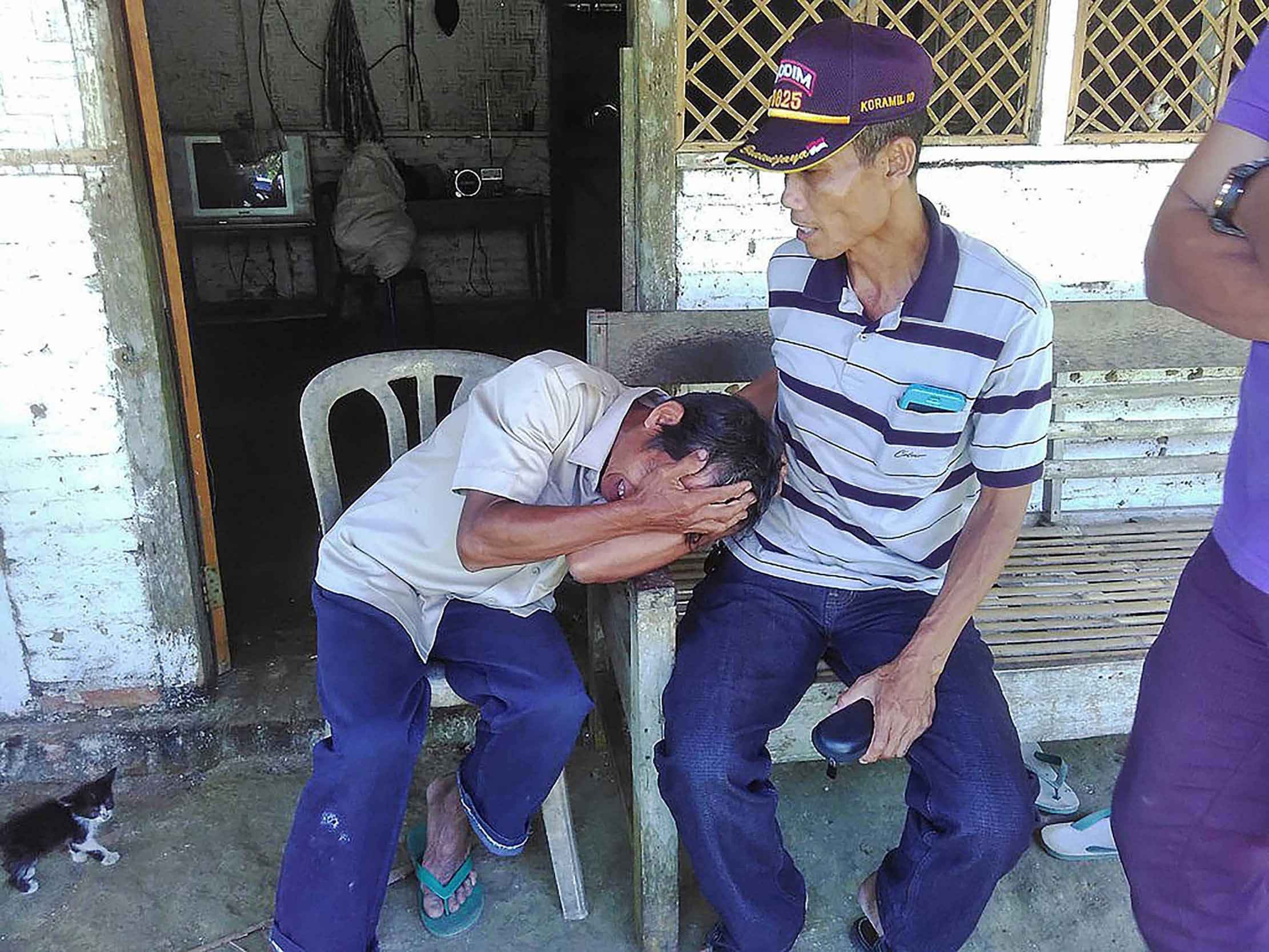 Kerabat menenangkan Mistaji (kiri), ayah Suliono, di rumahnya dii Desa Kandangan, Kecamatan Pesanggaran, Kabupaten Banyuwangi. JAWA POS RADAR BANYUWANGI