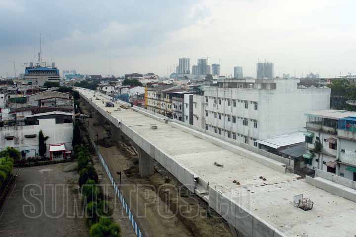 SUTAN SIREGAR/SUMUT POS HAMPIR SELESAI_Pekerja melintas di jalur layang kereta api yang hampir rampung di Jalan Emas Medan, Kamis (6/7) Jalur rel ganda yang ditargetkan selesai akhir tahun 2017 tersebut diharapkan dapat memacu pertumbuhan ekonomi Sumatera