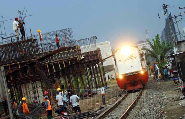 SUTAN SIREGAR/SUMUT POS REL LAYANG_Kereta lokomotif mengangkut barang tujuan belawan melintas dibawah pembangunan rel layang KA di Jalan Bambu 2 Medan, Selasa (6/2). Rel layang kereta api yang dibangun tersebut guna mendukung kelancaran transportasi.