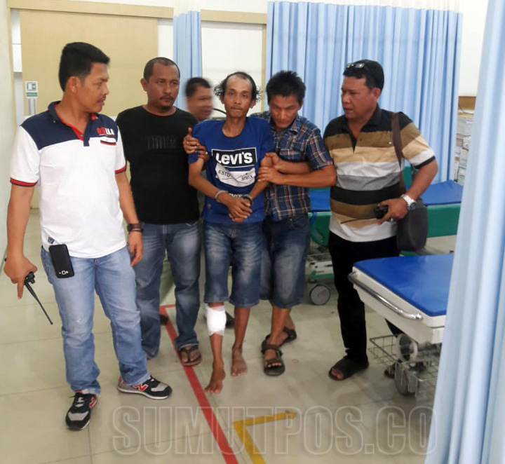 FOTO: FACRIL SYAHPUTRA/SUMUT POS  DIGOTONGl: Petugas Polsek Belawan mengotong Ari Gunawan alias Ari Botak ke rumah sakit untuk mengobati luka tembak di kakinya.