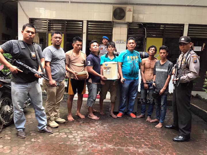 Kelima pelaku (dua dari kiri dan tiga pegang barang bukti) setelah diamankan di Polsek Medan Area.