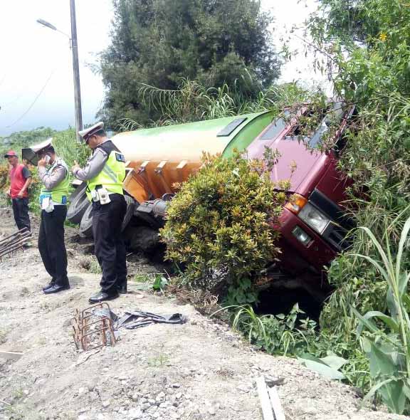 Petugas lalu lintas Polsek Pancurbatu melakukan olah tempat kejadian perkara di samping truk yang terguling, Rabu (11/4).