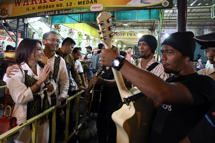 Calon wakil gubernur Sumatera Utara, Sihar Sitorus didampingi istrinya Patricia Siahaan bernyanyi bersama pengamen saat menyambangi tempat tongkrongan anak muda di Warkop Iwan, Jalan H.Misbah, Medan, akhir pekan lalu.