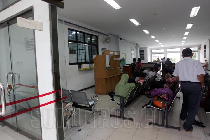 SUTAN SIREGAR/SUMUT POS Sejumlah keluarga pasien rawat inap duduk diruang tunggu lokasi pengambilan resep di Rumah Sakit Umum Pirngadi Jalan Perintis Kemerdekaan Medan, Selasa (23/l2). Jelang perayaan Hari Natal dan Tahun Baru Poliklinik tetap buka meskip