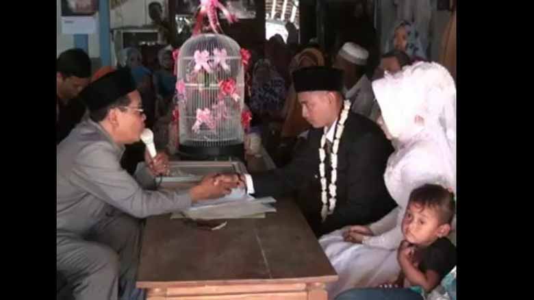 Potongan video prosesi ijab-kabul pengantin. Mempelai pria menjadikan burung lovebird sebagai maskawin.