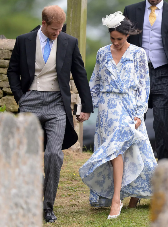 Meghan Markle dan Pangeran Harry. Meghan memilih gaun wrap panjang bermotif floral dengan material ringan yang menggelepai anggun ketika ia berjalan.