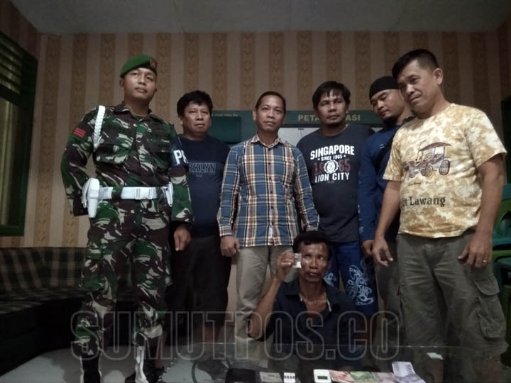 Foto: TEDDY/SUMUT POS BENDOL-BENDOL: Diapit Pasi Intel Kodim 0203/Langkat Kapten Slamat Jaya (kemeja kotak-kotak) dan beberapa prajurit, wajah Baharudin bendol-bendol saat memperlihatkan barang bukti.