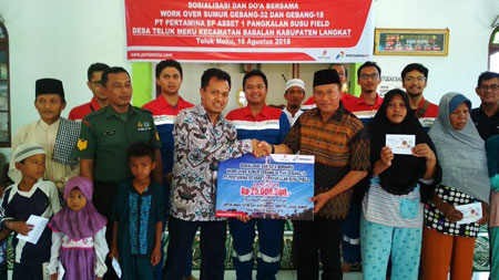 SANTUNI:Manager Pangkalan Susu Field, Sumadi Paryoto menyerahkan santunan kepada warga pada kegiatan doa bersama di Desa Teluk Meku.