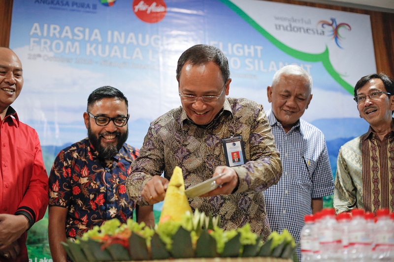 Foto: Air Asia  PENERBANGAN PERDANA:Sekretaris Kementerian Koordinator Bidang Kemaritiman Agus Purwoto meresmikan penerbangan perdana AirAsia rute Kuala Lumpur - Silangit bersama CEO AirAsia Malaysia Riad Asmat (kedua dari kiri), Bupati Tapanuli Utara Nik