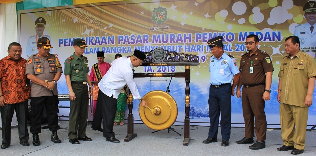 PUKUL GONG: Wali Kota Medan HT Dzulmi Eldin memukul gong tanda dibukanya secara simbolis 53 titik pasar murah yang tersebar di 21 kecamatan Kota Medan, Selasa (11/12). Tujuan kehadiran pasar murah itu guna membantu umat Kristiani, terutama yang kurang mam