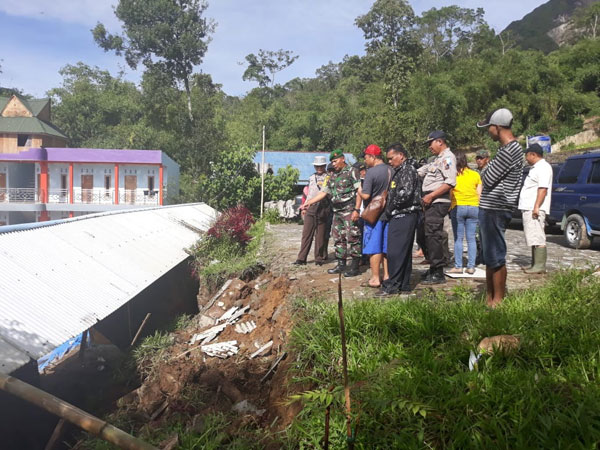 istimewa for SUMUT POS LONGSOR: Personel Polisi dan TNI serta warga menyaksikan dinding tebing yang longsor di pondok Pemandian Alam Daun Paris, Senin (3/12).