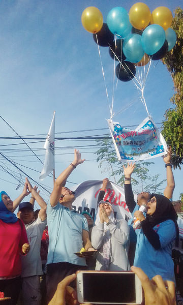 adezulfi/sumut pos LEPAS BALON: Ikhwan Ritonga bersama istri, Ina Faedah Nasution melepas balon ke udara sebagai tanda syukur atas bertambahnya usia, usai mengikuti Senam Sehat Sejati bersama ratusan warga. Jalan Bromo, Gang Setuju, Medan Denai, Minggu (2