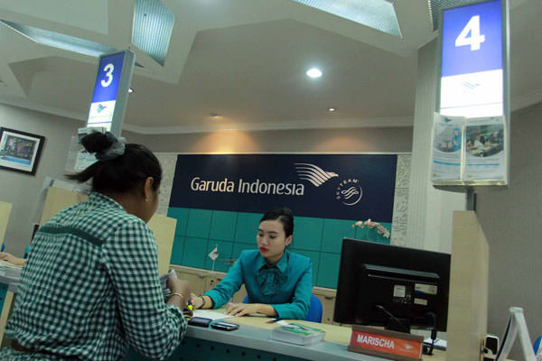 TRIADI WIBOWO/SUMUT POS TIKET: Karyawan maskapai Garuda Indonesia melayani calon penumpang di counter penjualan tiket Jalan Mongonsidi Medan, beberapa waktu lalu. Mulai Kamis (14/2) kemarin, Garuda Indonesia Group menurunkan harga tiket 20 persen.