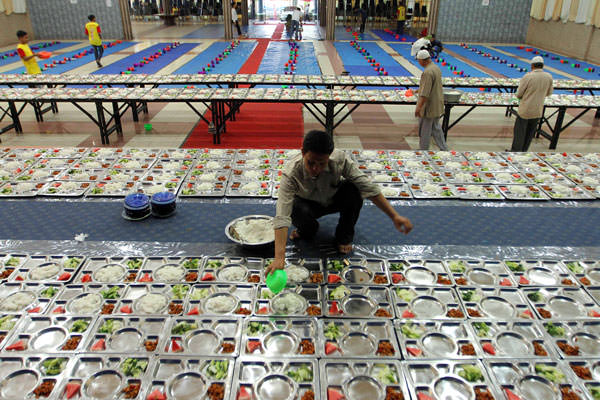 SUTAN SIREGAR/SUMUT POS makanan berbuka puasa: Seorang pengurus masjid menyajikan makanan berbuka puasa di Masjid Aceh Sepakat Jalan Mengkara Medan, Senin (13/5). Pengurus Masjid Aceh Sepakat setiap hari menyediakan menu berbuka puasa bagi masyarakat yang