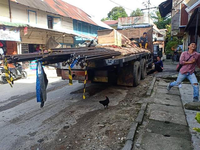 JALAN RUSAK - Truk pengangkut besi untuk kebutuhan material saat melintas di Kota Parlilitan, Humbahas. [Sunday Sihotang/New Tapanuli]
