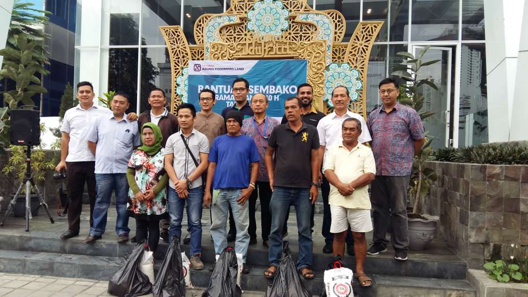 Foto: Istimewa DIABADIKAN: Anggiat Sihombing dan manajemen PT Sinar Menara Deli - Podomoro City Deli Medan diabadikan bersama warga seputaran proyek setelah menerima bantuan paket Lebaran, Jumat (31/5/2019). 
