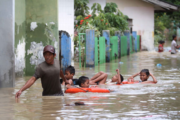 BANJIR: Warga beraktivitas di tengah banjir di Gang Merdeka Jalan Brigjen Katamo Medan, beberapa waktu lalu. Pemerintah Provinsi Sumatera Utara akan mengalokasikan anggaran sebesar Rp12,4 miliar untuk penanggulangan banjir Kota Medan dan sekitarnya.
