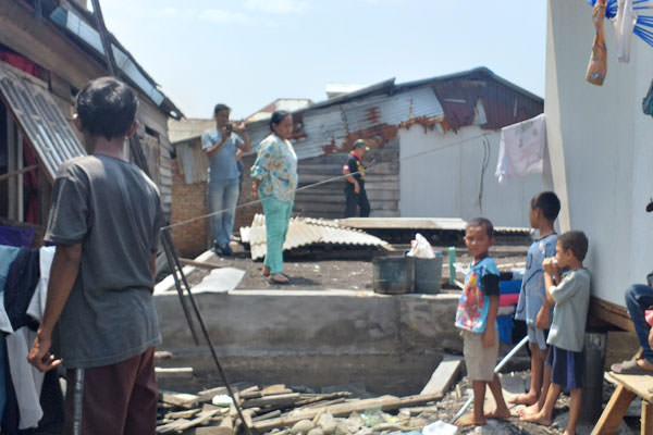 fachril/sumut pos BELUM DIBEDAH: Hadidah bersama Tokoh Masyarakat Bagan Deli, Khairudin  melihat pondasi rumahnya yang belum dibedah.