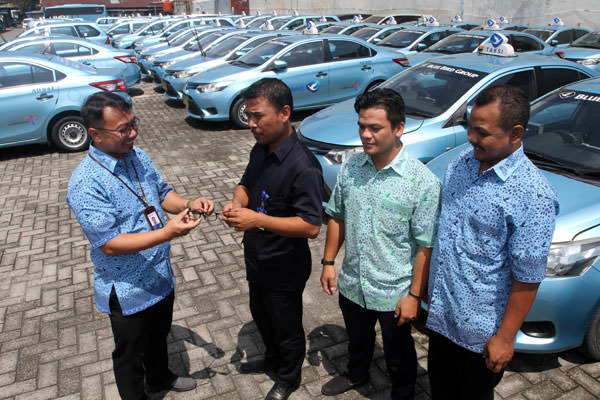 Triadi Wibowo/Sumut Pos  SIMBOLIS: GM Blue Bird Medan, Achmad Suhandi, menyerahkan secara simbolis kacamata kepada driver Blue Bird di Pool Blue Bird, Jalan kapten Muslim Medan.