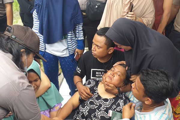 emilik rumah, Jualiarni, pingsan saat rumahnya dieksekusi.