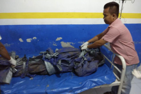BUKA: Petugas kamar mayat RSU Djasamen Saragih membuka salah satu mayat korban pembantaian dari  Dusun VI, Desa Wonosari, Kecamatan Panai Hilir, Kabupaten Labuhanbatu, Sumatera Utara.