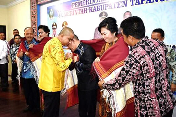 MEMBERIKAN ULOS: Bupati Tapteng, Bakhtiar Ahmad Sibarani memberikan ulos kepada Kajari  Sibolga Lama, Timbul Pasaribu, SH, dan Kajari Sibolga Baru, Hendri Nainggolan, SH.MH dalam acara pisah di Graha Aula Bank Indonesia Sibolga. ADLIN/SUMUT POS